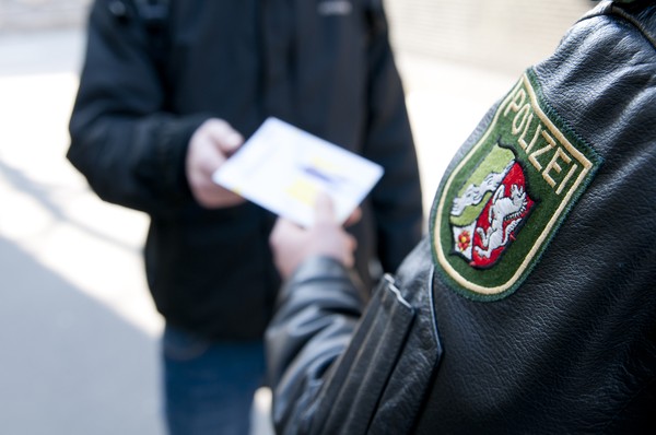 Ein Polizist gibt einem Jugendlichen eine FreD-Broschüre.